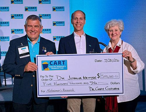  Professor Kritzer holds an oversized check with two CART representatives